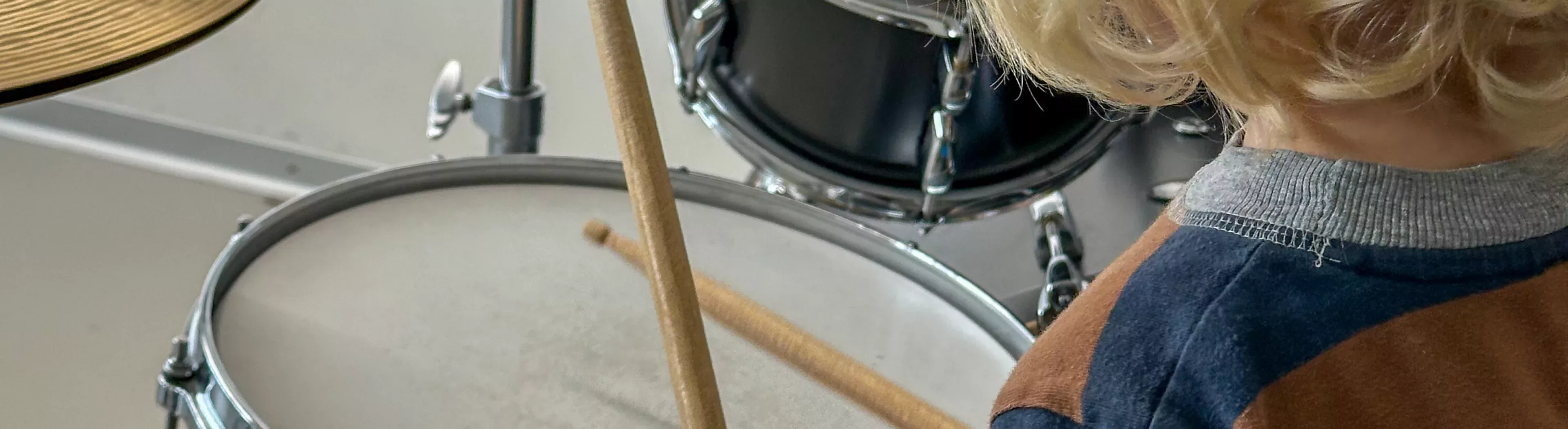 Kind spielt schlagzeug